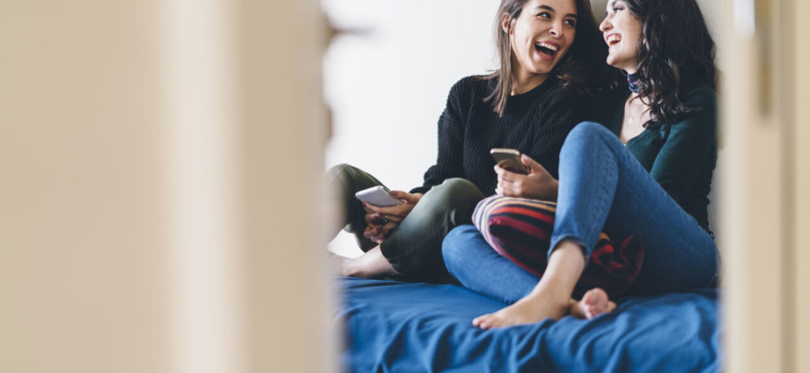 Two young women friends sharing happy time together