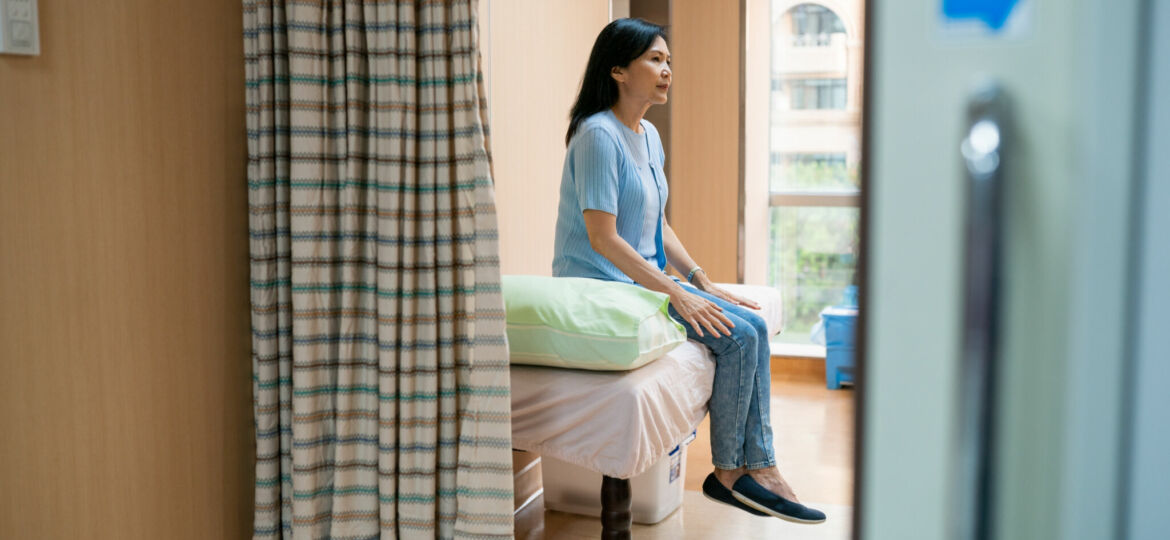 Female patient sitting on bed in doctor's office